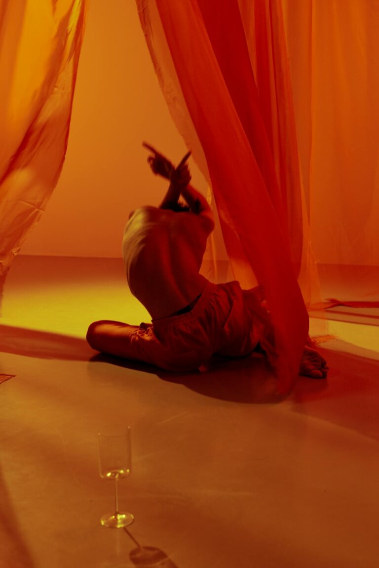 Conceptual dance performance with vibrant orange drapery and dynamic movement, perfect for artistic inspiration.